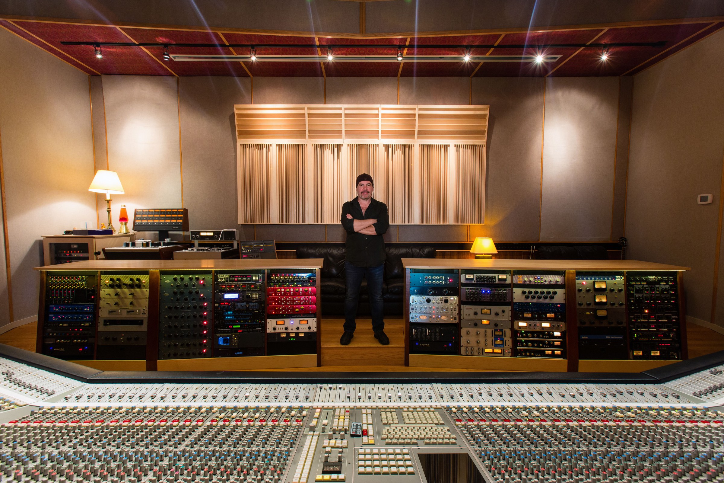 Will Schillinger standing with arms crossed behind the mixing console in the Pilot Recording Studios control room